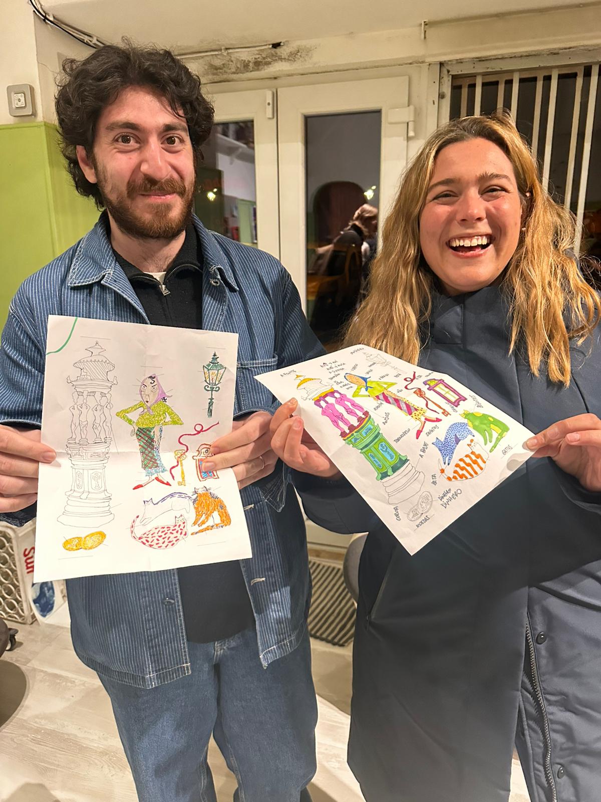 Two participants holding their coloured illustrations after an event